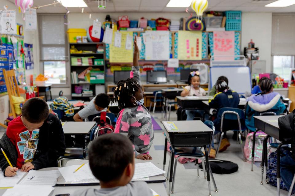 Second grader, Chelsea Kendall, 7, raises her hand at an after school tutoring program at Ecorse Ralph J. Bunche Elementary School on April 7, 2022, in Ecorse, Michigan. Staffing and logistical problems have limited several Michigan districts' abilities to run adequate tutoring programs.
