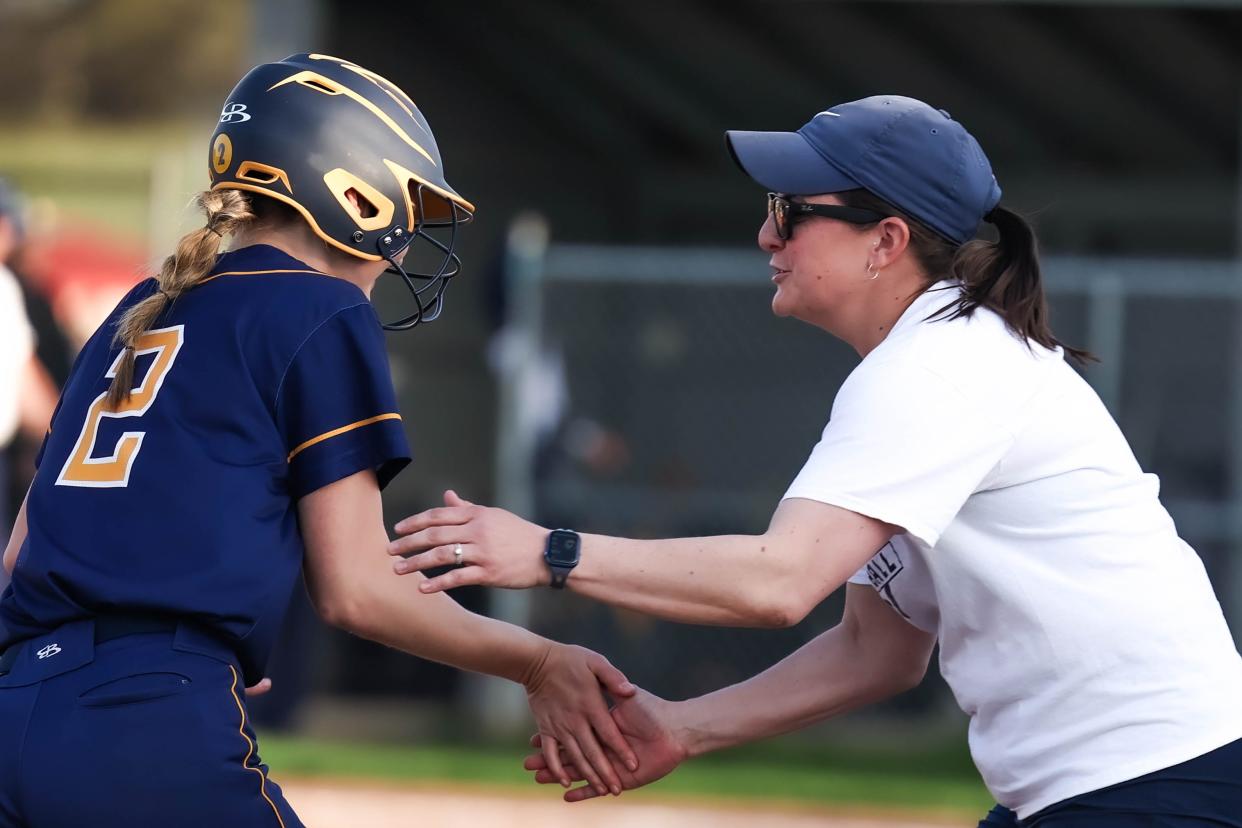 Coach Hannah Moore has a few words of celebration for Jordyn Fickes as she rounds third base this season. Moore announced she is stepping down after eight seasons with Hillsdale.