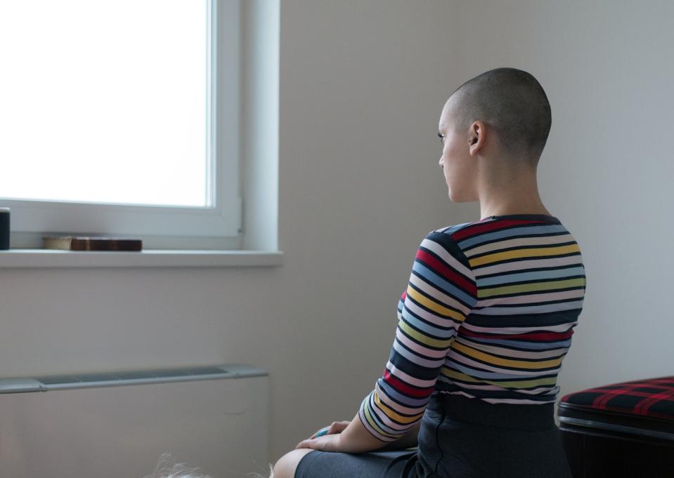 Person sitting by a window in a striped top, looking outside