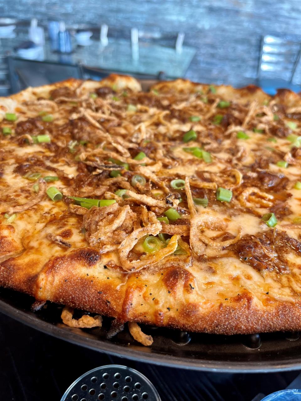 The Sooie pizza from High Tide Social House comes with white sauce, mozzarella/provolone, pulled pork, SoHo sauce, green onion and frizzled onion.