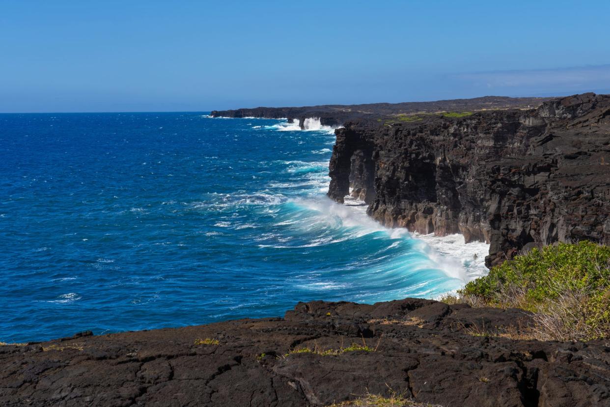 Pacific waves crash against Hōlei Sea Arch and steep lava cliffs at the bottom of Chain of Craters Road at Hawaiʻi Volcanoes National Park.