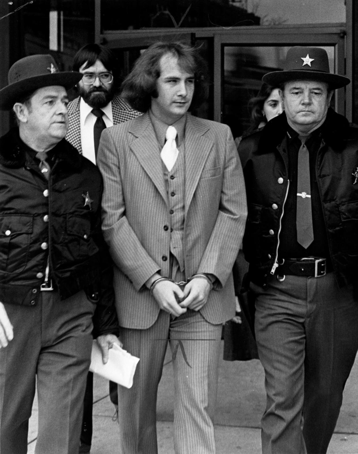 William Stanley "Billy" Milligan leaves the Franklin County Hall of Justice on December 4, 1978 after being found innocent by reason of insanity of a series of Ohio State University-area crimes. He is being escorted by Franklin County Sheriff's Sgt. Frank Bonner, left, and Deputy Jack Reiser. Probate Court Judge Richard Metcalf later sent Milligan to a mental hospital for treatment, according to court sources.