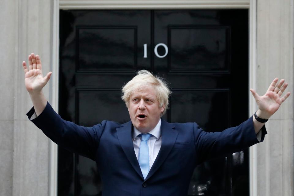 Britain's Prime Minister Boris Johnson participates in a national "clap for carers" to show thanks for the work of Britain's NHS (National Health Service) workers and other frontline medical staff around the country as they battle with the novel coronavirus pandemic, outside 10 Downing Street in London on May 21, 2020. - The British government on on May 21 announced that foreign care workers would be exempt from a charge imposed on migrants to fund the health service, after an outcry sparked by the coronavirus outbreak. (Photo by Tolga AKMEN / AFP) (Photo by TOLGA AKMEN/AFP via Getty Images)