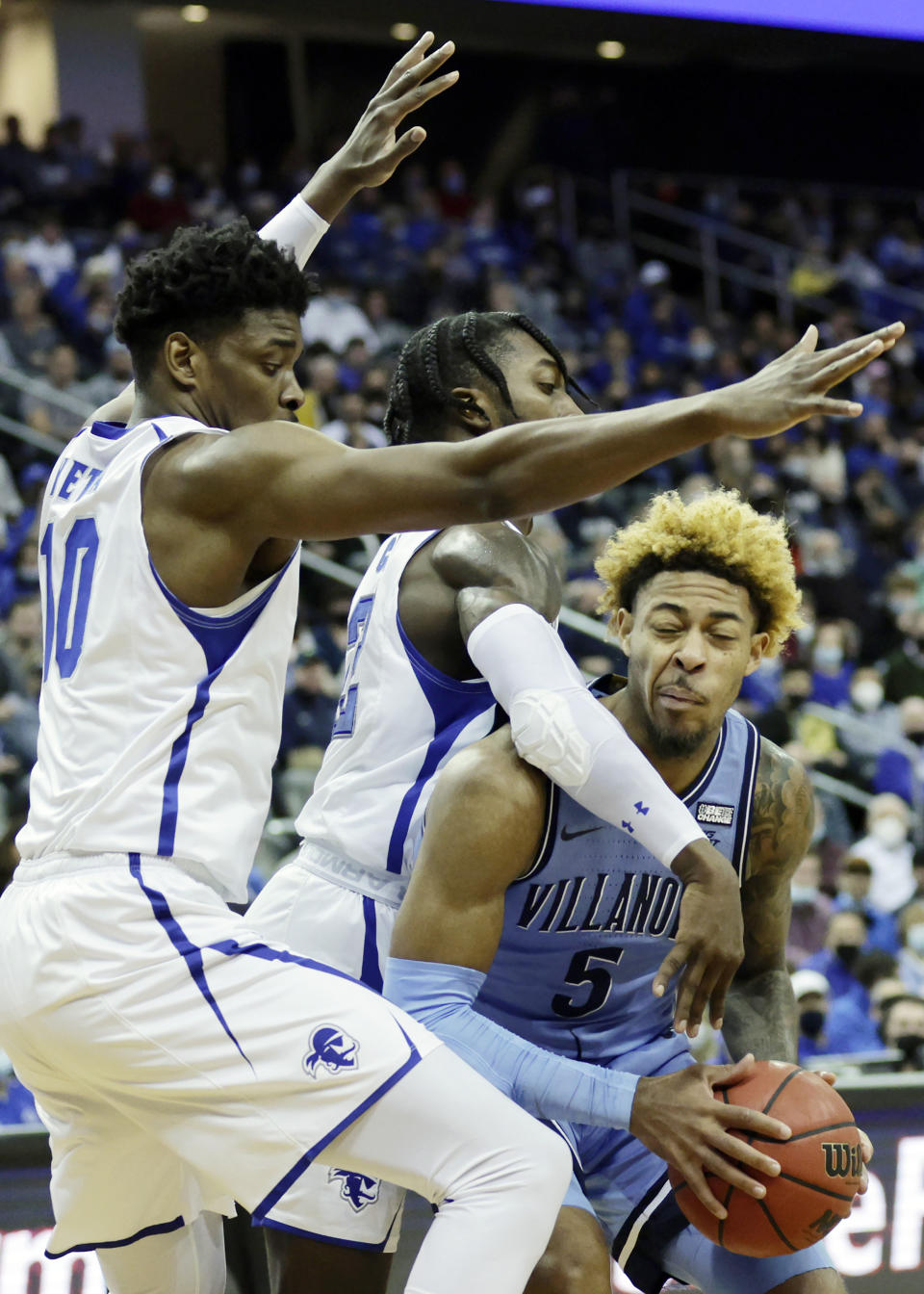 Villanova guard Justin Moore (5) is fouled by Seton Hall forward Tray Jackson in front of Alexis Yetna (10) during the first half of an NCAA college basketball game Saturday, Jan. 1, 2022, in Newark, N.J. (AP Photo/Adam Hunger)