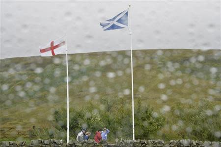 Scottish and English flags flutter in the wind and rain at the border between England and Scotland at Carter Bar September 6, 2013. REUTERS/Toby Melville