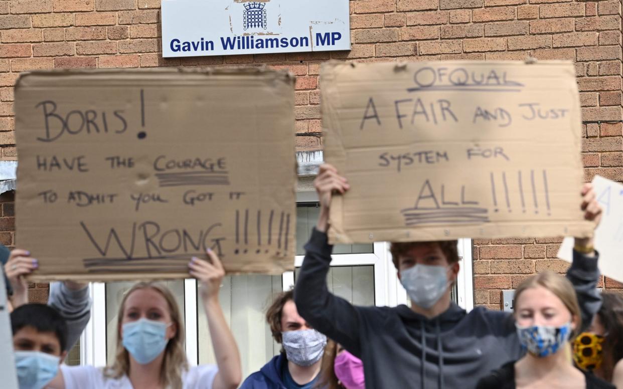 Students hold placards outside Gavin Williamson's constituency office - Paul Ellis/AFP