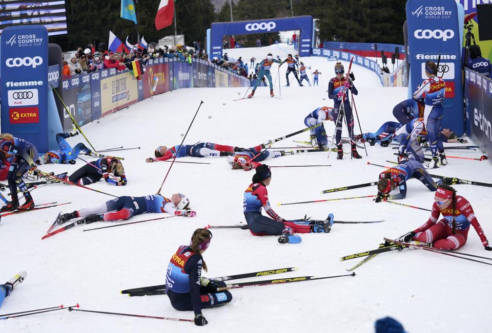 Participants recover at the finish line during the Women's Mass Start Free 10km event at the Tour de Ski in Val di Fiemme, Trento, Italy, Tuesday, Jan. 4, 2022. (AP Photo/Giovanni Auletta)