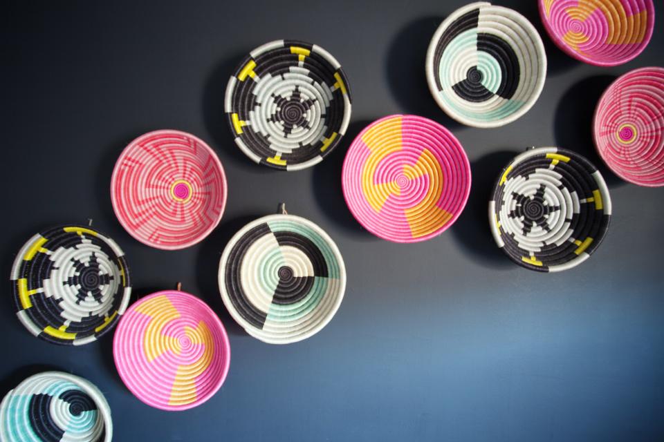 Colorful woven bowls on the wall of a project by Brooklyn duo AphroChic.