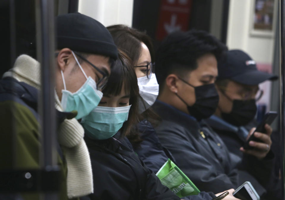 People in Taiwan wear protective face masks at a metro station in Taipei, Taiwan, Sunday, Feb. 9, 2020. China's virus death toll rose by 89 on Sunday to 811, passing the number of fatalities in the 2002-2003 SARS epidemic, but fewer new cases were reported in a possible sign its spread may be slowing as other nations stepped up efforts to block the disease. (AP Photo/Chiang Ying-ying)