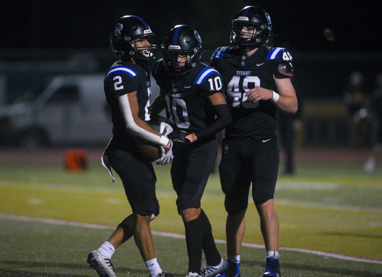 Central Bucks South's Anthony Leonardi (2) celebrates one of his three touchdowns against Pennridge with teammates Matt Harmon (10) and Sean Moskowitz (48) during an October 2023 game.