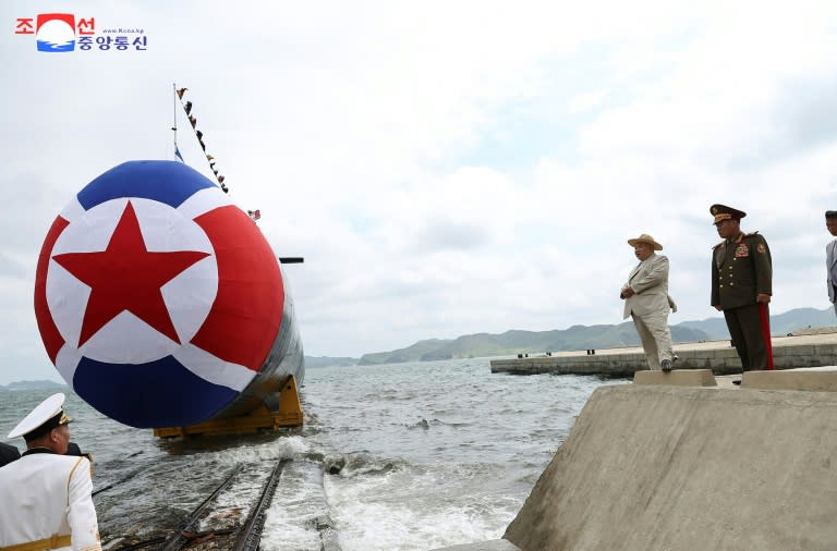 North Korean leader Kim Jong Un (2nd R) next to the country's new submarine (STR)