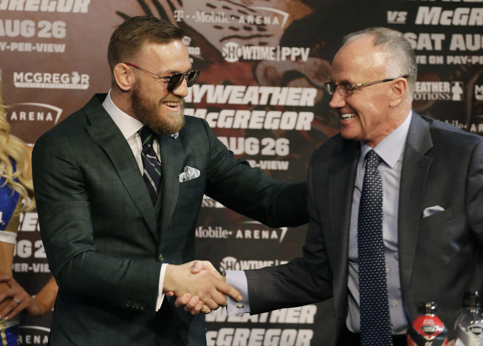 Conor McGregor, left, shakes hands with Bob Bennett during news conference Wednesday, Aug. 23, 2017, in Las Vegas. McGregor is scheduled to fight Floyd Mayweather Jr. in a boxing match Saturday in Las Vegas. (AP Photo/John Locher)