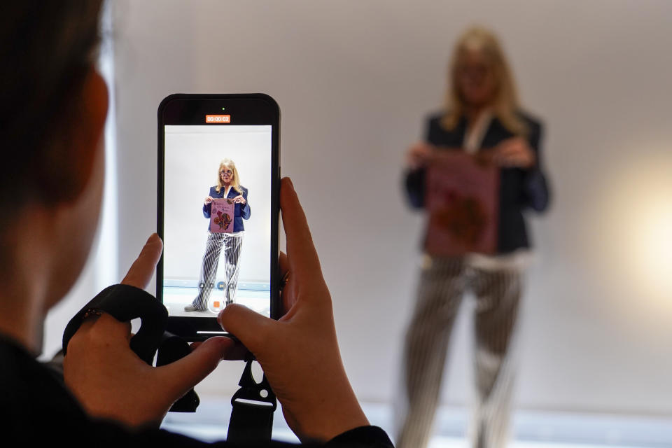 Pattie Boyd holds a Christmas Card written by George Harrison as part of The Pattie Boyd Collection at Christie's, in London, Thursday, March 14, 2024. The card is estimated to sell £3,000-5,000. (AP Photo/Alberto Pezzali)