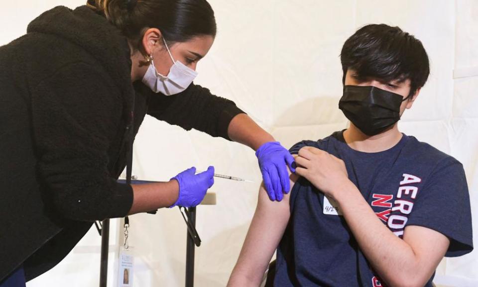 Anthony Briseno, 20, receives his first Pfizer Covid-19 shot at Abraham Lincoln High School in Los Angeles. Children aged 12-15 are also now authorized to have the vaccine.