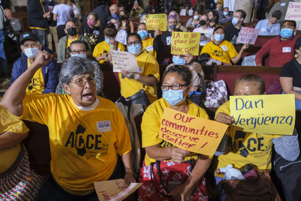 FILE - People hold signs and shout slogans before the starting the Los Angeles City Council meeting on Tuesday, Oct. 11, 2022 in Los Angeles. Cross-cultural coalitions have ruled Los Angeles politics for decades, helping elect both Black and Latino politicians to top leadership roles in the racially and ethnically diverse second largest city in America. But the year old recording of racist comments by the city's City Council president has laid bare the tensions over political power that have long quietly simmered between the Latino and Black communities. (AP Photo/Ringo H.W. Chiu, File)