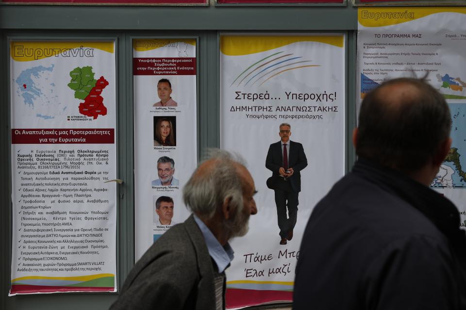 In this Tuesday, May 14, 2019, photo an elderly man passes election posters in Karpenisi town at Evrytania region, in central Greece. As balloting for the European Parliament gets underway Thursday and continues through Sunday voters over 55 are emerging as a powerful bloc on a rapidly aging continent as younger voters stay away from the polls in growing numbers. (AP Photo/Thanassis Stavrakis)