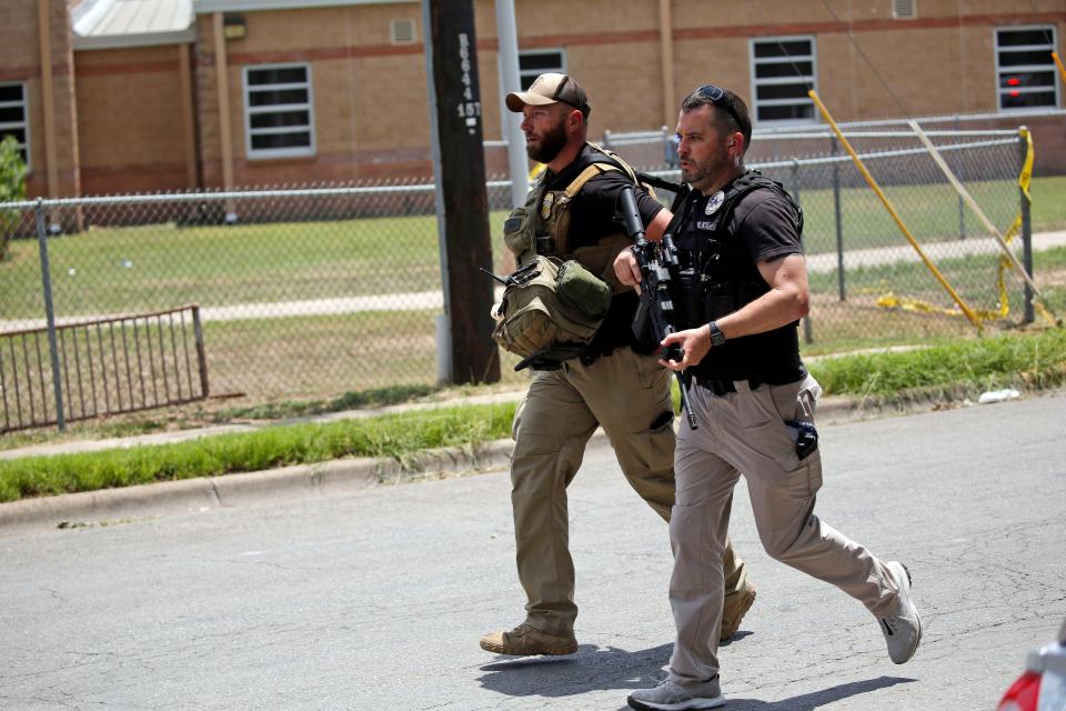 Police walk near Robb Elementary School following a shooting, Tuesday, May 24, 2022, in Uvalde, Texas.