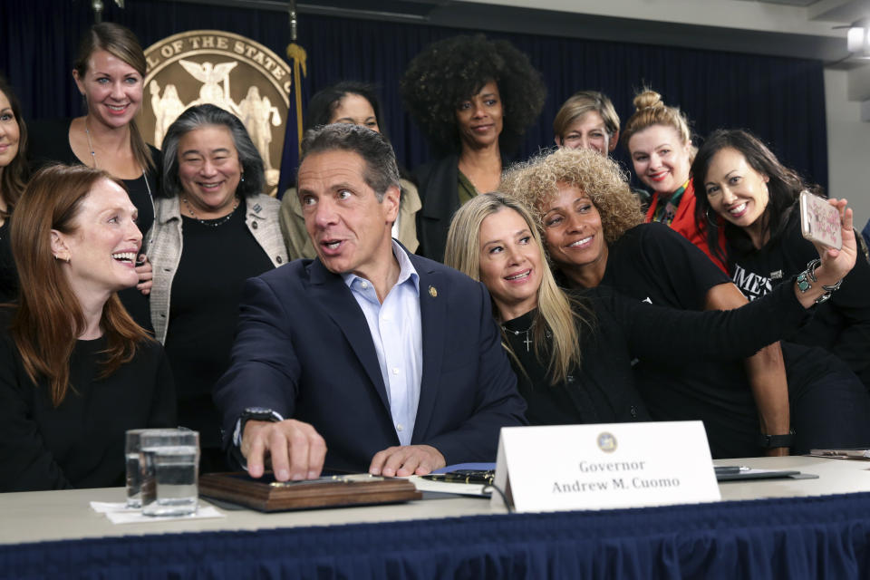 Surrounded by supporters and activists, New York Gov. Andrew Cuomo signs a bill that increases the statute of limitations in rape cases during a bill signing ceremony in New York, Wednesday, Sept. 18, 2019. Actresses Julianne Moore, left, Mira Sorvino, fourth from right, and Michele Hurd, third from right, were there as supporters of the bill and as members of the Time's Up movement, which advocates for women's rights. (AP Photo/Seth Wenig)