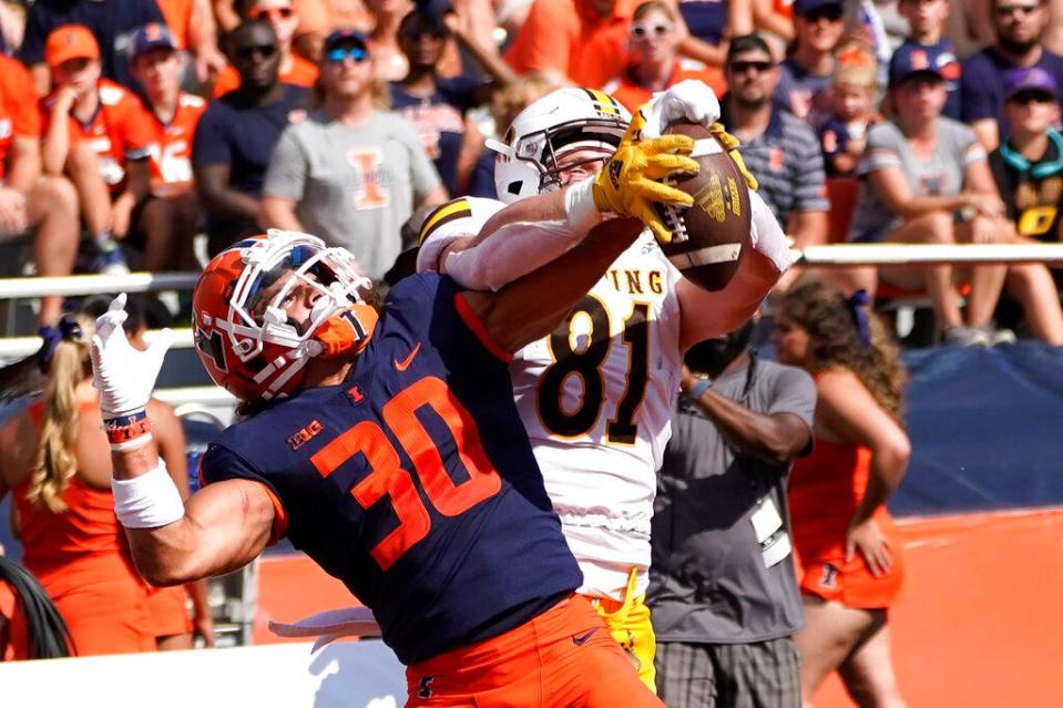 Illinois defensive back Sydney Brown (30) breaks up a pass intended for Wyoming tight end Treyton Welch in the end zone during an NCAA college football game, Sunday, Aug.  28, 2022, in Champaign, Ill.  (AP Photo/Charles Rex Arbogast)