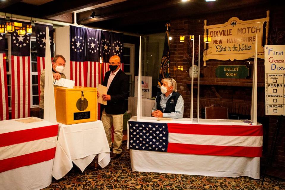 Tom Tillotson drops voters ballots into the ballot box at the Hale House at the historic Balsams Resort during midnight voting as part of the first ballots cast in the United States Presidential Election in Dixville Notch, New Hampshire.