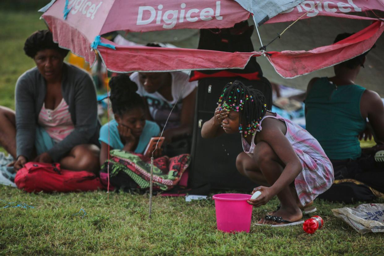 A girl washes her face after spending the night at a soccer field following Saturday's 7.2 magnitude earthquake in Les Cayes, Haiti, Sunday, Aug. 15, 2021.