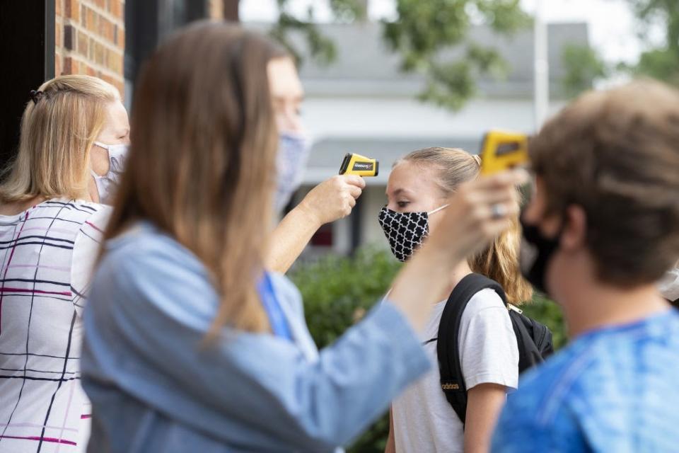 Sept. 1: Students wearing masks have their temperatures checked before entering Logan Jr. High School in Princeton, Illinois. (Getty Images)