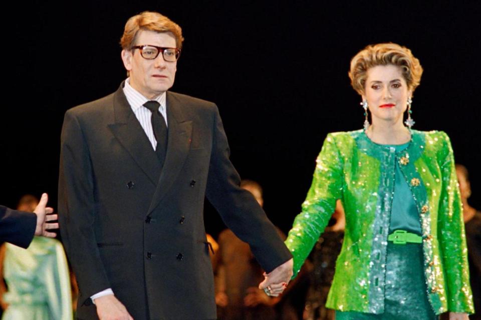 Yves Saint-Laurent and Catherine Deneuve on February 3, 1992, during the show celebrating the 30 year anniversary of the Yves Saint-Laurent House at the Bastille Opera in Paris. (AFP/Getty Images)