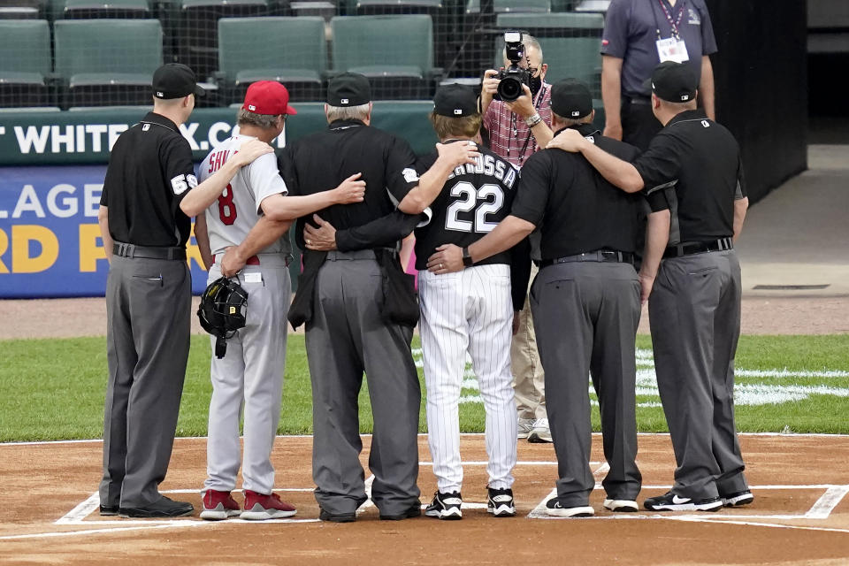 Umpire Joe West, third from left, poses for photos his fellow umpires, St. Louis Cardinals manager Mike Shildt (8) and Chicago White Sox manager Tony La Russa before a baseball game Tuesday, May 25, 2021, in Chicago. West set a record of 5,376 games when he worked Tuesday night's game. (AP Photo/Charles Rex Arbogast)