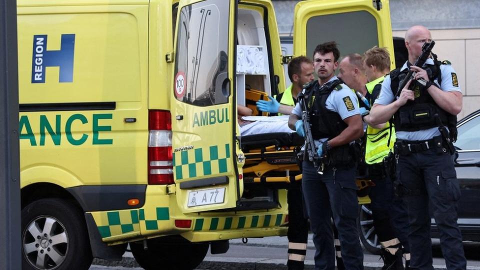 Police and ambulance workers stand outside the shopping centre