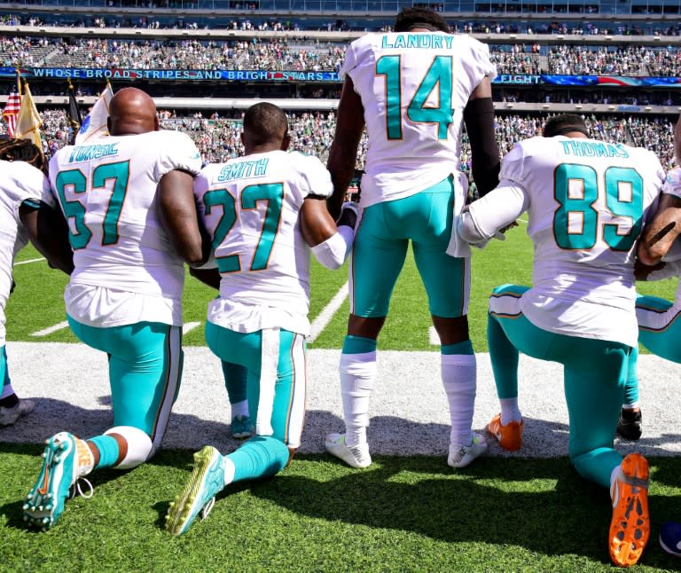 Miami Dolphins players kneel in protest during the national anthem before the start of an NFL game against the New York Jets at MetLife Stadium