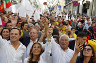 Portuguese Prime Minister and Socialist Party leader Antonio Costa, center right, with his wife Fernanda Tadeu, center, and Lisbon Mayor Fernando Medina, left, wave to supporters during an election campaign action in downtown Lisbon Friday, Oct. 4, 2019. Portugal will hold a general election on Oct. 6 in which voters will choose members of the next Portuguese parliament. The ruling Socialist Party hopes an economic recovery during its four years of governing will persuade voters to return the party to power. (AP Photo/Armando Franca)