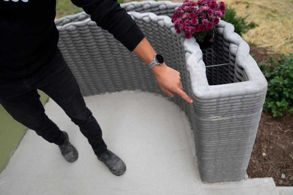 Fernando Bales, 35, of Pontiac, build lab manager of Citizen Robotics, also has the distinction of being the builder of record for Michigan's first 3D-printed house in Detroit, points to a 3D-printed flower box on the front porch on Monday, Sept. 25, 2023.