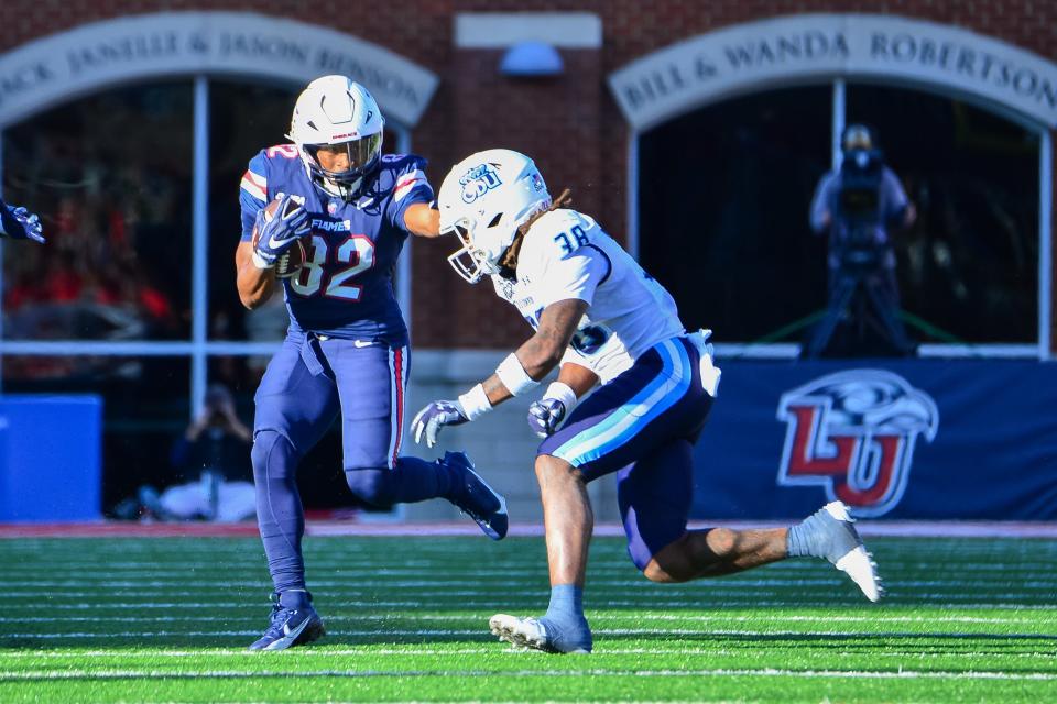 Liberty wide receiver Aaron Bedgood (82) runs after a catch while being pursued by Old Dominion safety Ashton Whitner (38) at Williams Stadium.