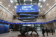People walk under a screen showing the KOSPI, Korea Composite Stock Price Index, at the Korea Exchange in Seoul, South Korea, Thursday, Jan. 2, 2020. Asian shares were mostly higher on optimism about a U.S.-China trade deal as most of the region's markets opened the new year's first day of trading Thursday. (AP Photo/Ahn Young-joon)