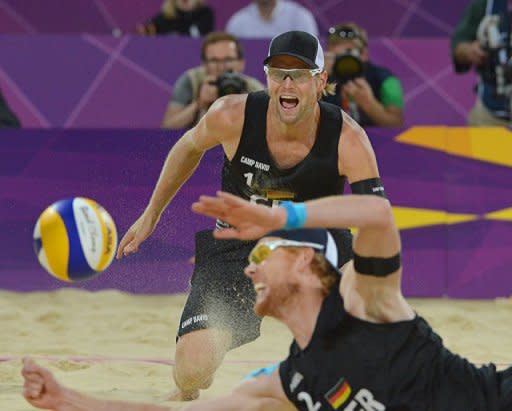 Germany's right blocker Jonas Reckermann (foreground) dives to reach the ball as teammate Julius Brink looks on during the men's beach volleyball final match on The Centre Court at Horse Guards Parade in London during the London 2012 Olympics Games. German pair Jonas Reckermann and Julius Brink became Europe's first Olympic beach volleyball champions