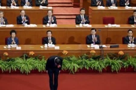 China's President Xi Jinping (top row, 2nd R) and other delegates clap as China's Premier Li Keqiang bows during the opening session of the National People's Congress (NPC) at the Great Hall of the People in Beijing, China, March 5, 2016. REUTERS/Jason Lee