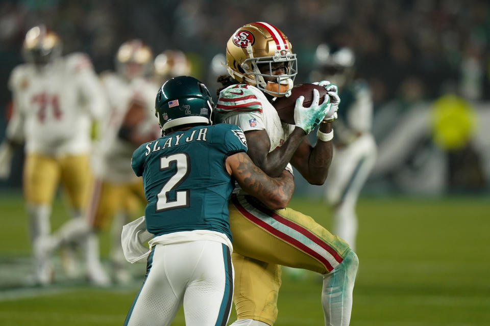 San Francisco 49ers wide receiver Brandon Aiyuk, right, makes a catch as Philadelphia Eagles cornerback Darius Slay (2) applies a hit during the first half of an NFL football game, Sunday, Dec. 3, 2023, in Philadelphia. (AP Photo/Chris Szagola)