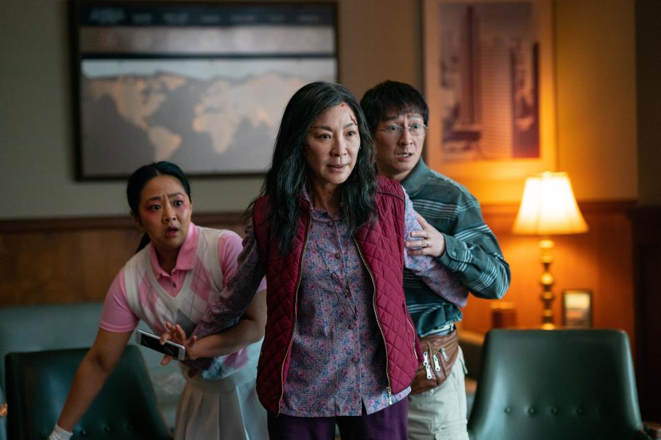 Evelyn (Michelle Yeoh, left), her daughter Joy (Stephanie Hsu) and husband Waymond (Ke Huy Quan) star in "Everything Everywhere All at Once." If you've ever wondered to yourself, "how would Michelle Yeoh do kung fu if her fingers were literal giant uncooked hotdogs" (and who among us hasn't wondered that), this movie has answers for you.