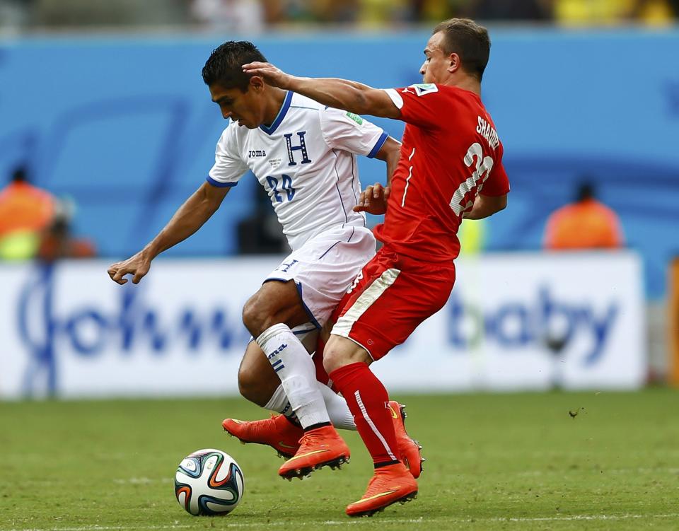 Switzerland's Xherdan Shaqiri (R) fights for the ball with Jorge Claros of Honduras during their 2014 World Cup Group E soccer match at the Amazonia arena in Manaus June 25, 2014. REUTERS/Dominic Ebenbichler (BRAZIL - Tags: SOCCER SPORT WORLD CUP)