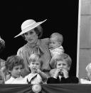 <p>Princess Diana holds baby Prince Harry, as Lord Frederick Windsor, Prince William and Peter Phillips watch on. (PA Images)</p> 