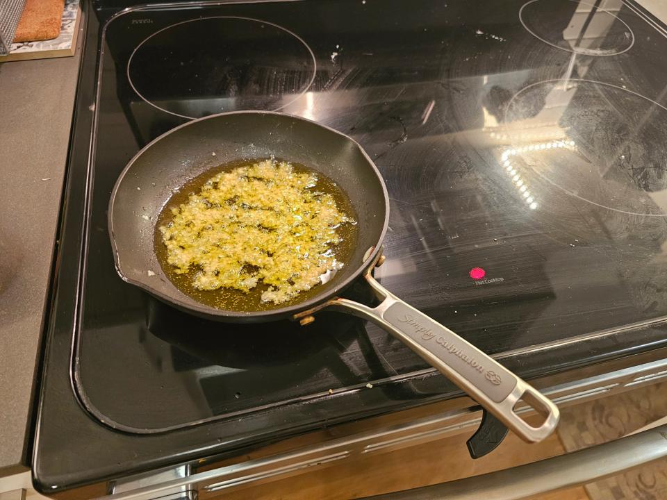 Minced garlic in oil on a pan on a hot stovetop