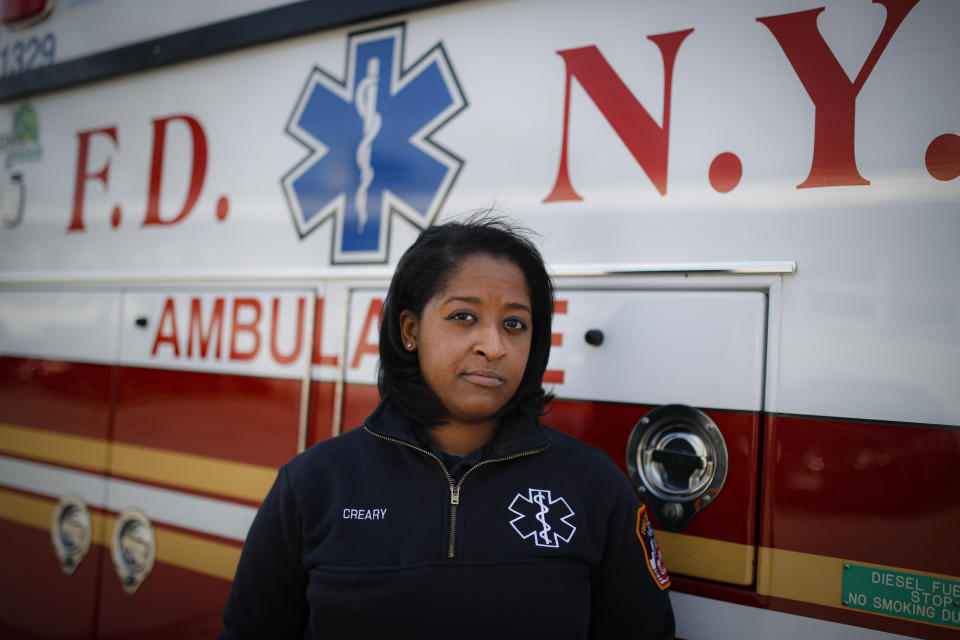 Virginia Creary, a 911 dispatcher, stands for a portrait outside her station house, Tuesday, April 7, 2020, in the Bronx borough of New York. The new normal for New York City's emergency workers has come down to this: 911 operators bracing each day for a deluge of calls from a panicked public, dispatchers scrambling to respond and ambulance workers following a "viral pandemic triage" protocol with life-or-death consequences. (AP Photo/John Minchillo)