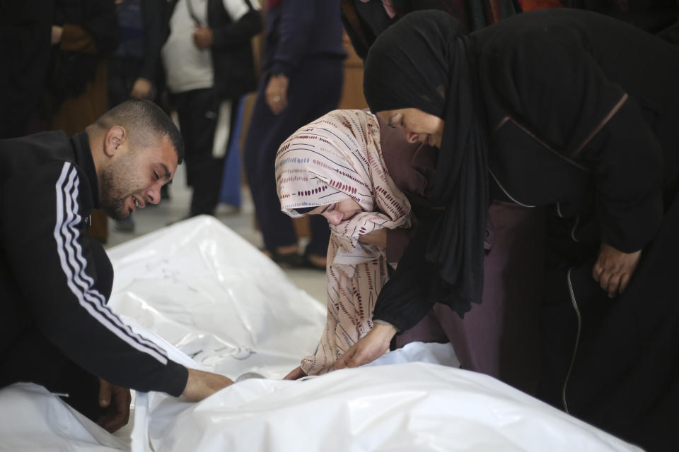 Palestinians mourn relatives killed in the Israeli bombardment of the Gaza Strip in Khan Younis, Tuesday, Dec. 26, 2023. (AP Photo/Hatem Ali)