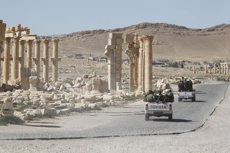 Syrian army soldiers drive past the Arch of Triumph in the historic city of Palmyra, in Homs Governorate, Syria in this April 1, 2016 file photo. REUTERS/Omar Sanadiki/Files