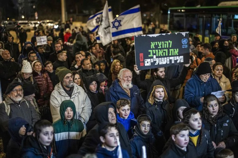 Israelíes participan en una protesta frente a la sede de la Agencia de Obras Públicas y Socorro de las Naciones Unidas para los Refugiados de Palestina en el Cercano Oriente (OOPS) en Jerusalén, pidiendo que se ponga fin a la actividad de la organización, tras informes de que trabajadores de la UNWRA participaron en el ataque de Hamás del 7 de octubre.