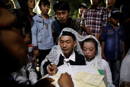 A couple takes part in a mass wedding organised by the city government as part of New Year's Eve celebrations in Jakarta, Indonesia, December 31, 2017. REUTERS/Darren Whiteside