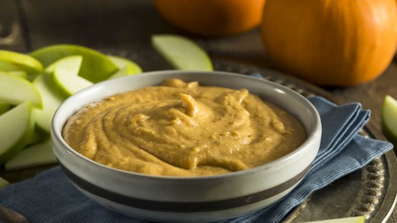 pumpkin dip in striped dish on blue towel