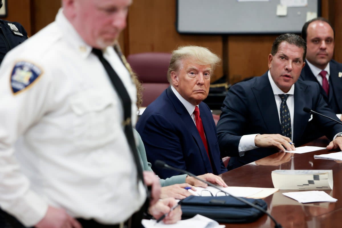 Donald Trump sits in the courtroom at Manhattan Criminal Court in New York City with his attorneys Joe Tacopina and Boris Epshteyn during his arraignment hearing on 4 April 2023 (Getty)