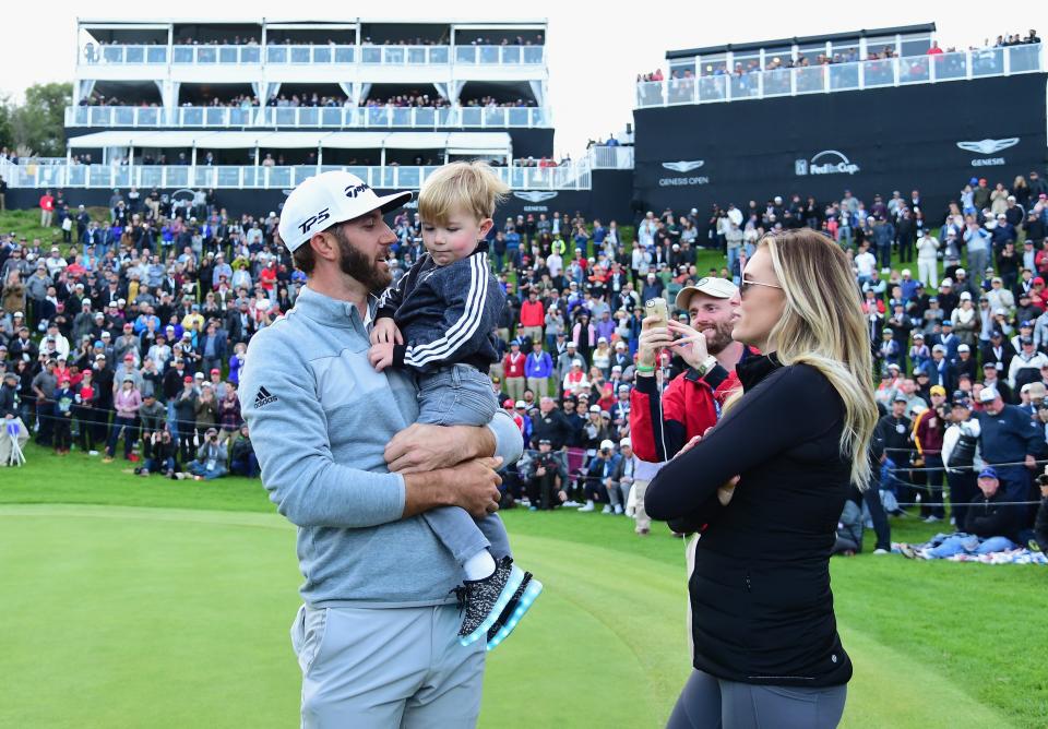 Dustin Johnson celebrates with Paulina Gretzky and son Tatum on the 18th green after winning the Genesis Open at Riviera Country Club on Feb. 19, 2017, in Pacific Palisades, California.