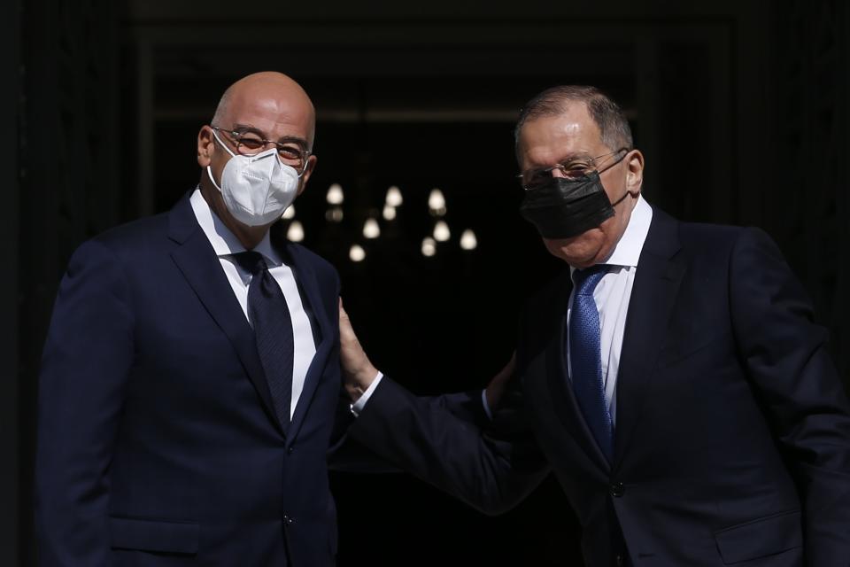Greek Foreign Minister Nikos Dendias, left, welcomes his Russian counterpart Sergei Lavrov before their meeting in Athens, Monday, Oct. 26, 2020. The talks of the two diplomats are focussed on the situation between Greece and Turkey as the neighbour country announced late Saturday that it is extending by one week a gas exploration mission in the eastern Mediterranean that has caused tensions with Greece. (Costas Baltas/Pool via AP)
